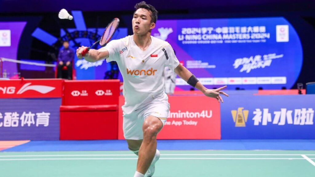 Indonesia's Jonatan Christie, in white uniform, returns a shot in Shenzhen. Christie beats Loh in early marquee matchup