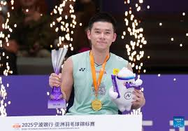 Kunlavut vzitidsarn shows off his trophy and prizes after winning the 2025 Badminton Asia Championships title.
